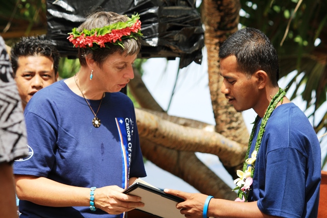 English and Math instructor Jane Evans presents one of the graduates with his certificate.