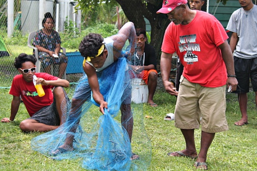 Master Canoe builder Binton Daniel teaching Atnel Tabu throw netting. Photo: Sealand Laiden
